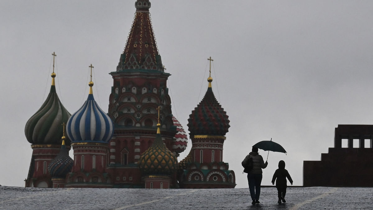 A woman and a child walk on Red Square in front of St. Basil's Cathedral in Moscow on October 3, 2022. Credit: AFP Photo