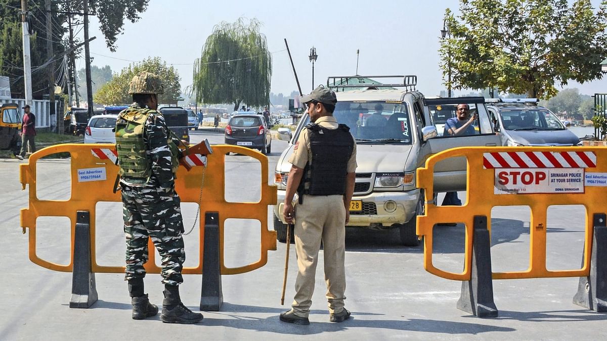 Security personnel stand guard near the Raj Bhavan where Union Home Minister Amit Shah is scheduled to inaugurate various projects, in Srinagar. Credit: PTI Photo