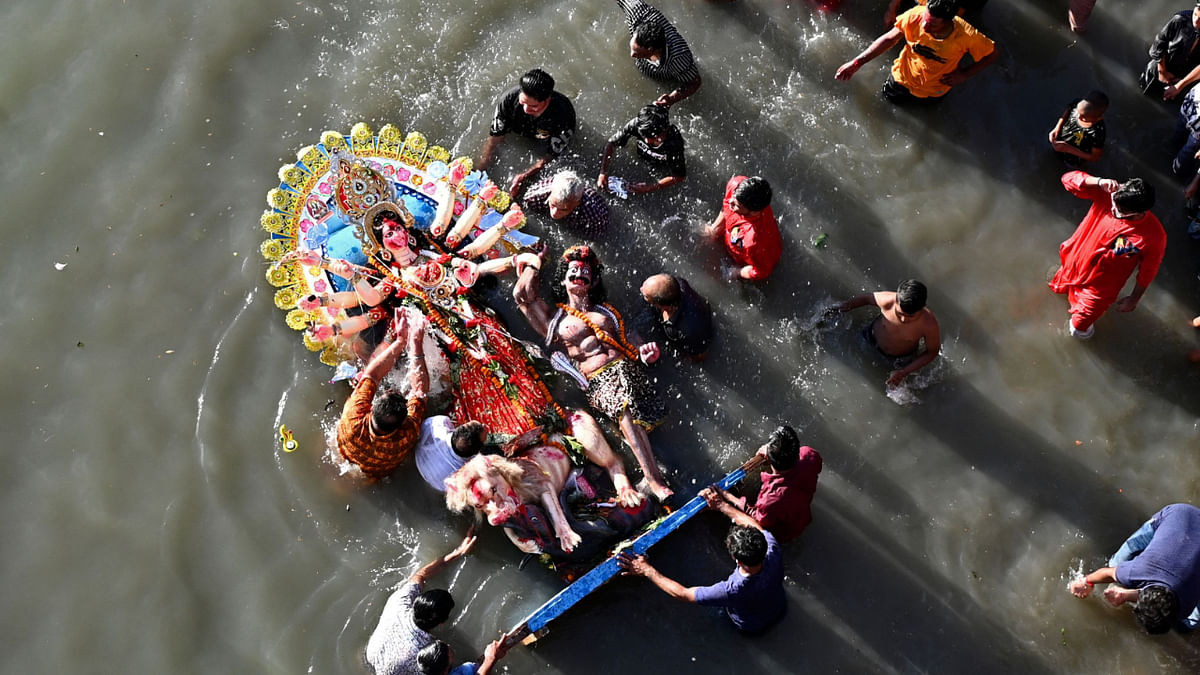 Devotees prepare to immerse an idol of the Hindu Goddess Durga in the Buriganga River on the final day of the Durga Puja festival in Dhaka on October 5, 2022. Credit: AFP Photo