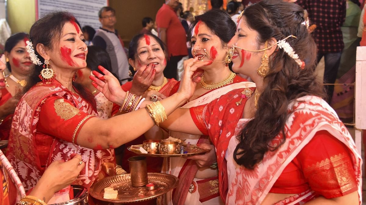 Women apply vermillion on each other as they participate in 'Sindoor Khela' on the last day of Durga Puja festival celebrations, in Jaipur. Credit: PTI Photo