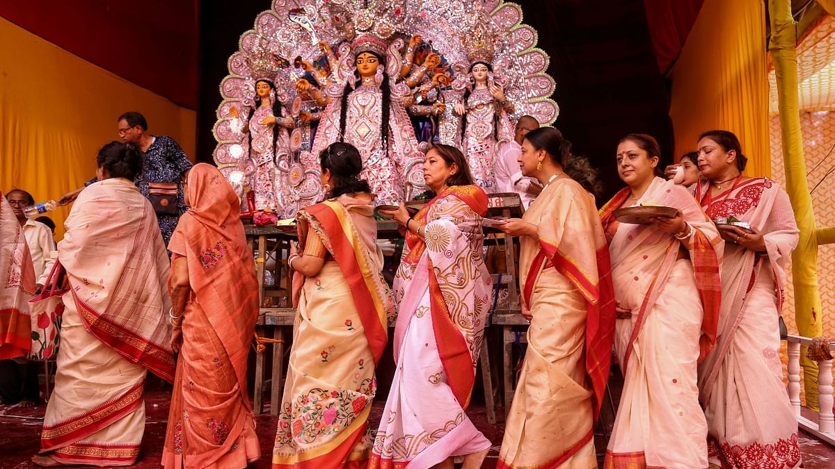 Women offer prayers before the 'Sindoor Khela' on the last day of Durga Puja festival celebrations, at Chittaranjan Park in New Delhi. Credit: PTI Photo