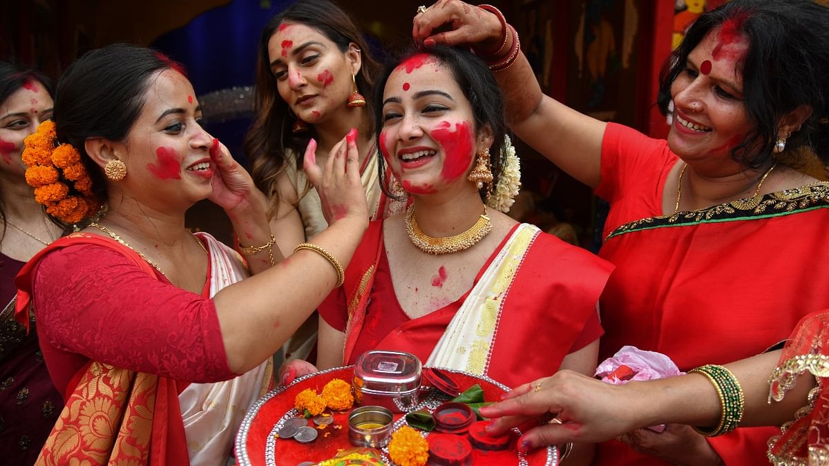Married women apply vermillion on each other as they participate in 'Sindoor Khela' on the last day of Durga Puja festival celebrations, in Chandigarh. Credit: PTI Photo