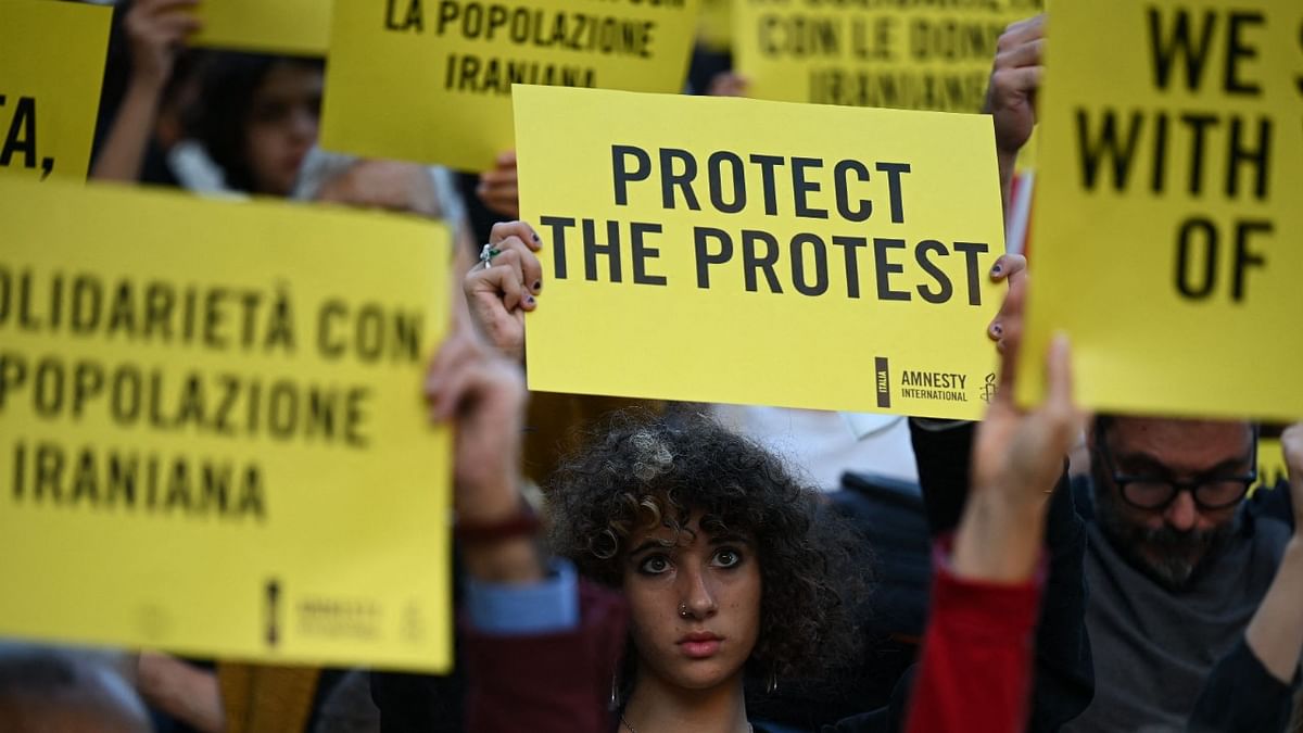 Protesters hold slogans during a demonstration in solidarity with Iranian women and protestors in Piazza del Campidoglio in Rome. Credit: AFP Photo