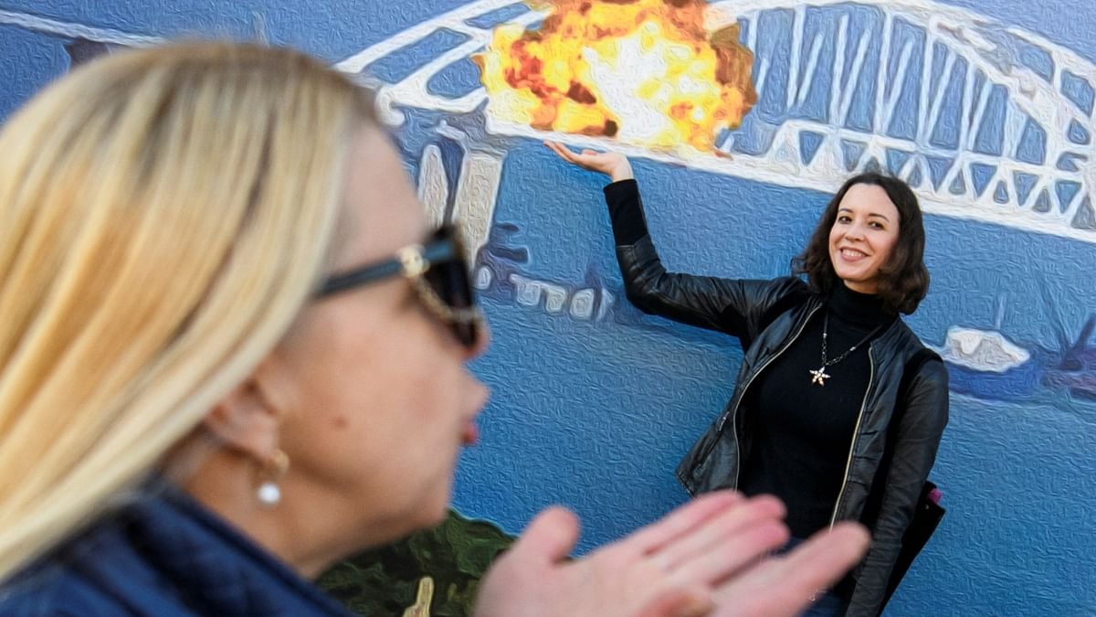 In another creative pose, a woman stood in front of the artwork with her hand placed under the portrayal of the blast. Credit: Reuters Photo