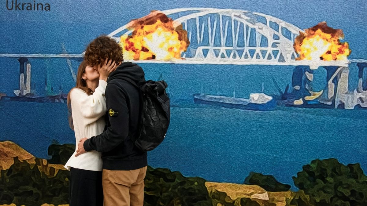 A couple expressed their love and kissed in front of the artwork depicting Kerch bridge on fire. Credit: Reuters Photo