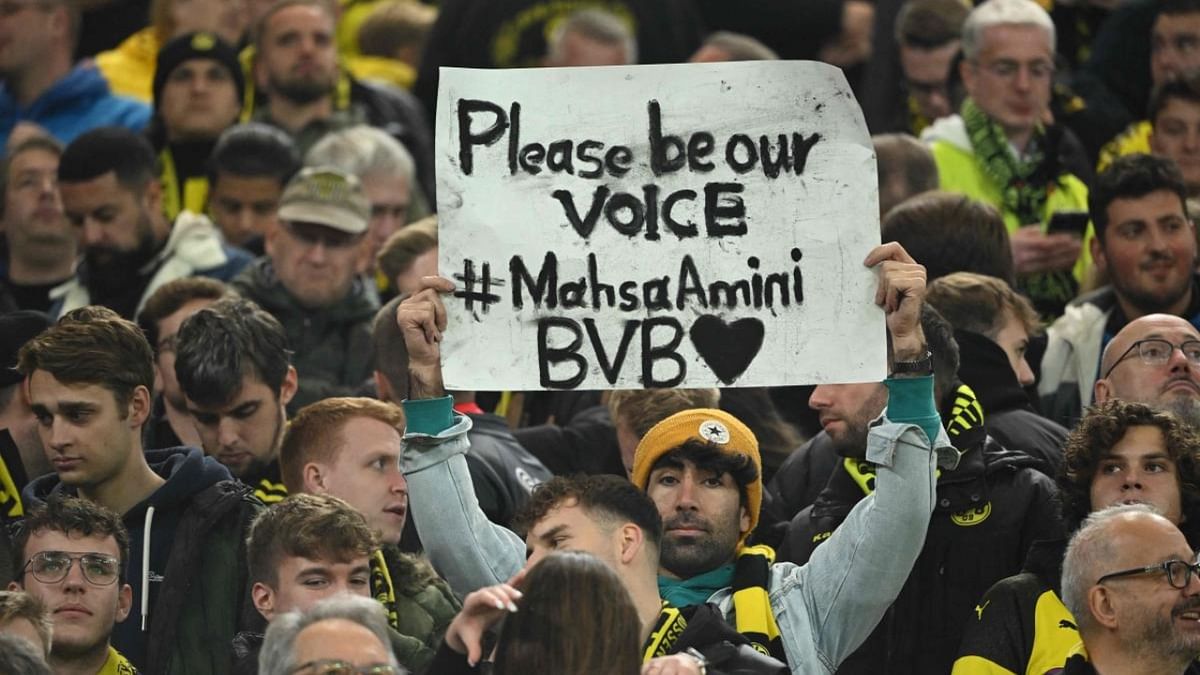 A spectator holds a placard to protest against the death of 22-year-old Mahsa Amini during the UEFA Champions League group G football match Borussia Dortmund vs Sevilla FC in Dortmund, western Germany, on October 11, 2022. Credit: AFP Photo