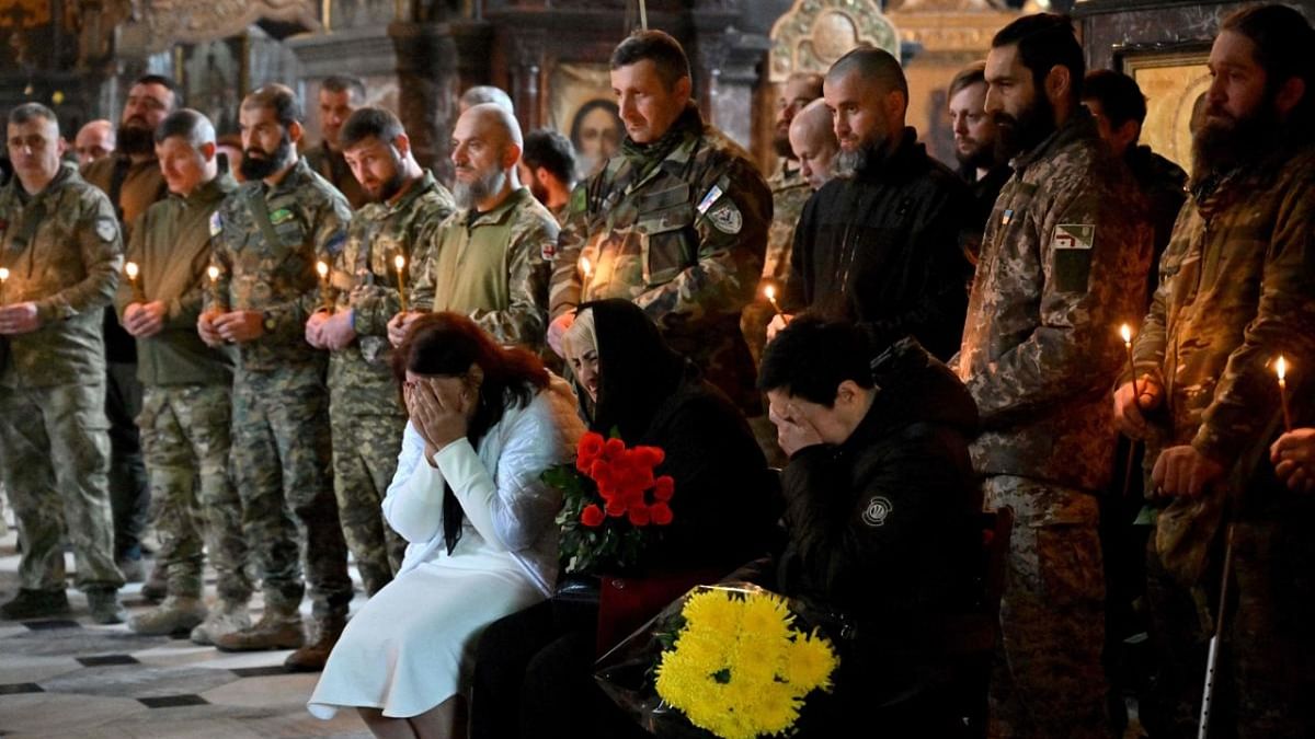 Relatives and servicemen attend the funeral service for Edisher Kvaratskhelia, a Georgian volunteer part of the Ukrainian battalion Kievan Rus, who died in combat in Volododymyr cathedral in Kyiv on October 13, 2022, amid Russian invasion of Ukraine. Credit: AFP Photo