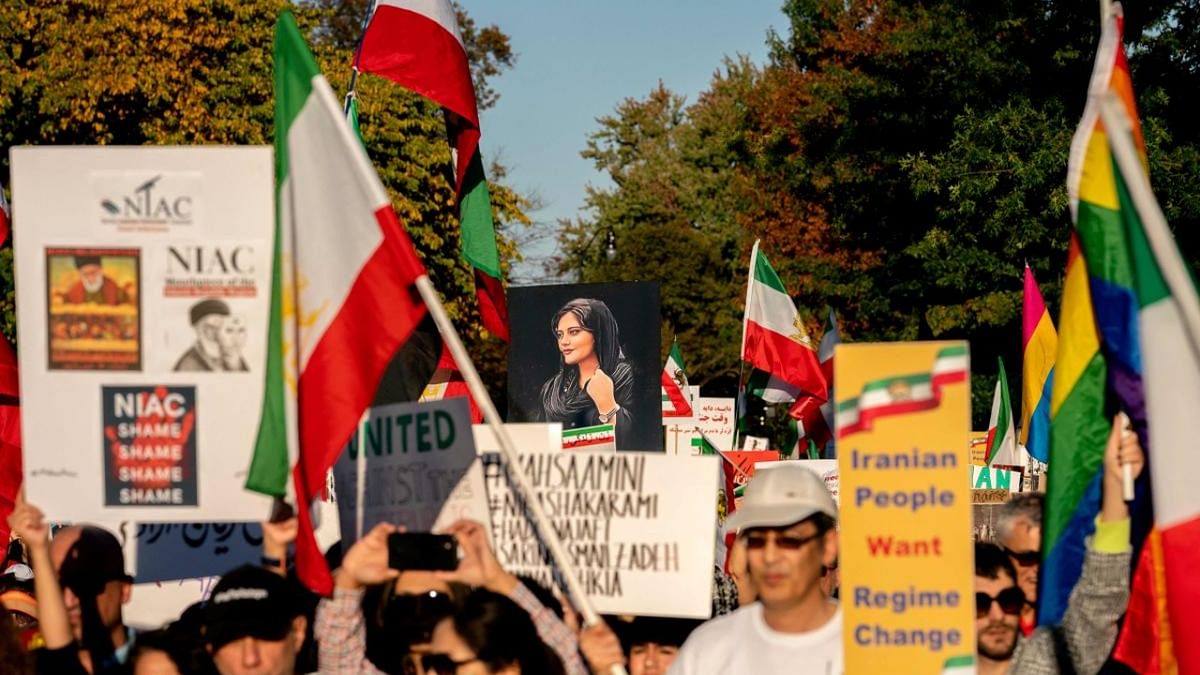 Demonstrators chant slogans and wave Iranian flags during the