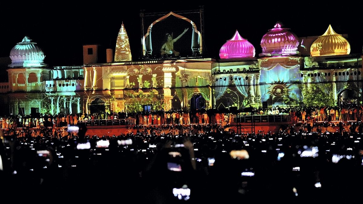 Devotees witness laser light show on the banks of the Saryu river during Deepotsav celebrations, on the eve of the Diwali festival, in Ayodhya. Credit: PTI Photo