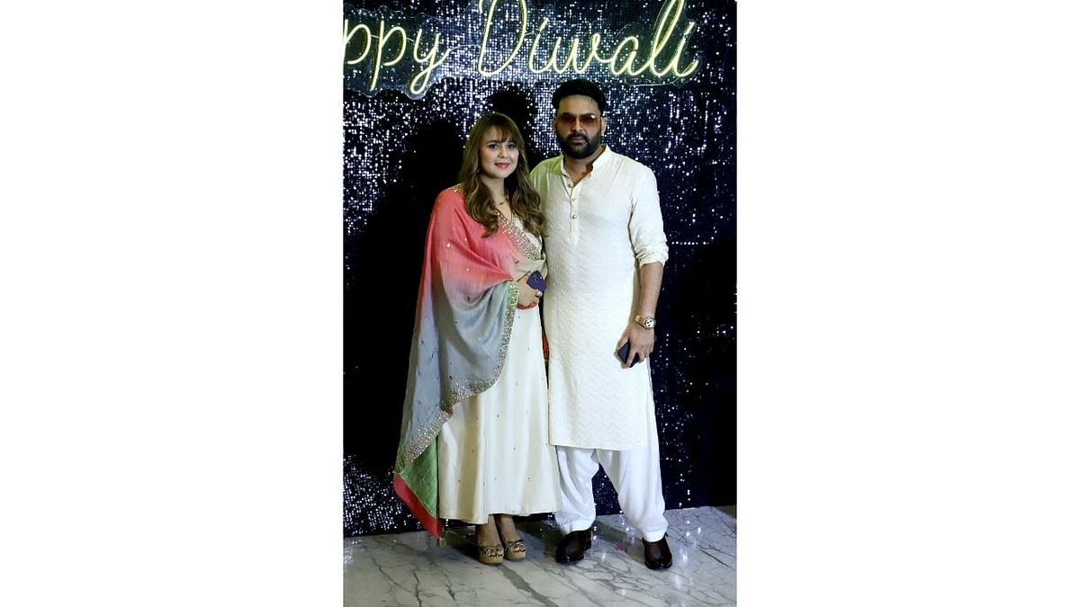 Kapil Sharma poses with his wife Ginni Chatrath as he arrives for Krishan Kumar’s Diwali party. Credit: PTI Photo