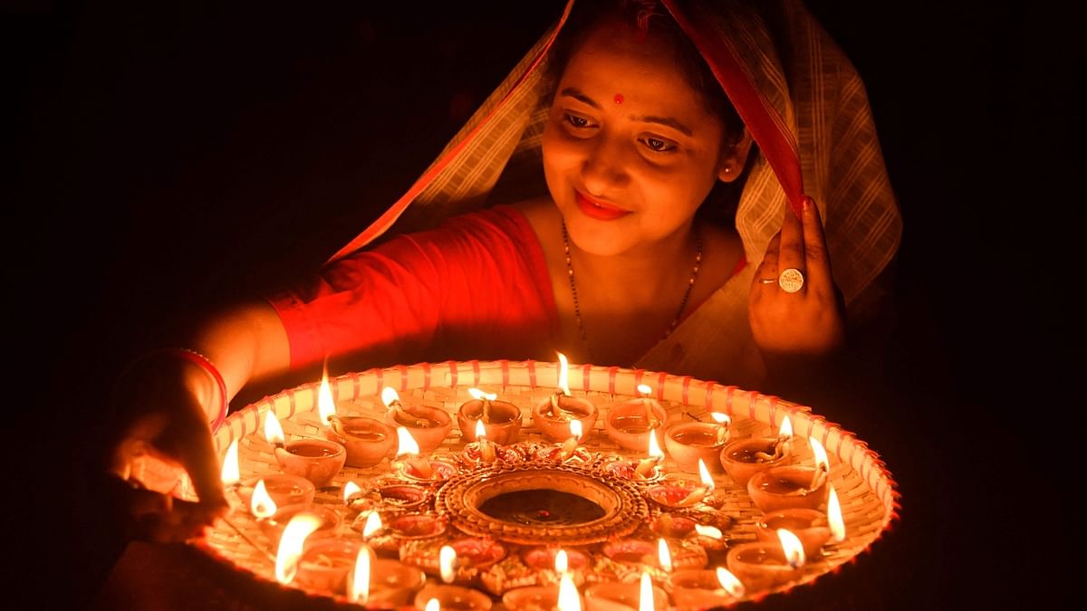 A woman lights earthen lamps on the occasion of Diwali at her house in Guwahati. Credit: AFP Photo