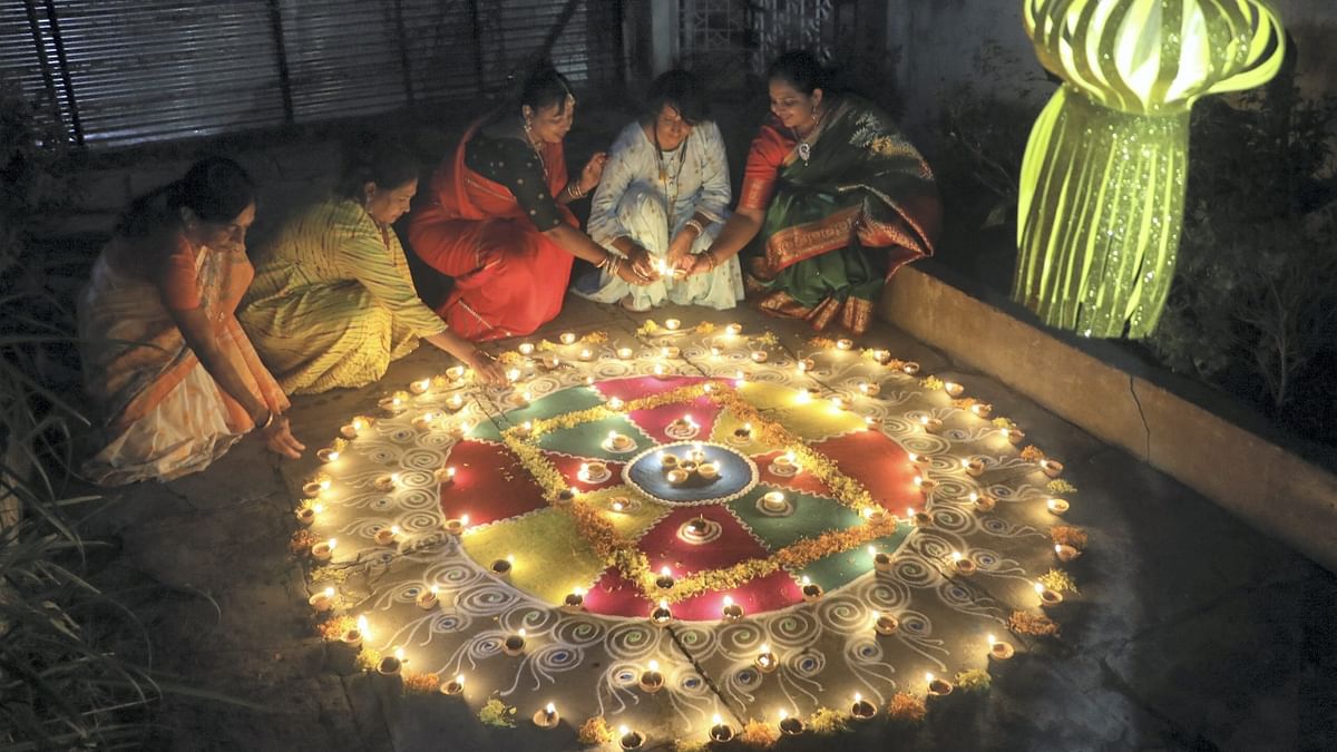 Women decorate a 'rangoli' with earthen lamps on the occasion of Diwali in Nagpur. Credit: PTI Photo