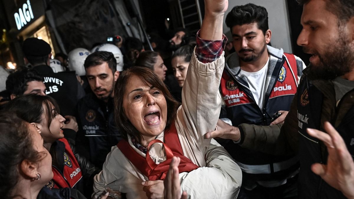 A protester flashes a victory sign as she is detained by Turkish anti-riot police officers during a demonstration in Istanbul on October 26, 2022, after the President of the Union of Doctors of Turkey (TTB), Sebnem Korur Fincanci was arrested. Credit: AFP Photo