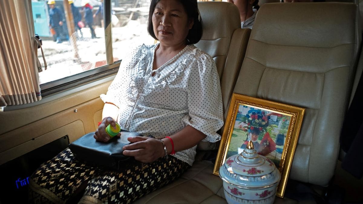 Saowanee Donchot, 52, sits next to the urn containing the ashes of her granddaughter Pattanan Mumklang (known as