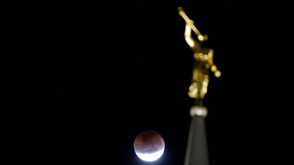 The moon and a statue are seen during the lunar eclipse in San Salvador, El Salvador. Credit: Reuters Photo