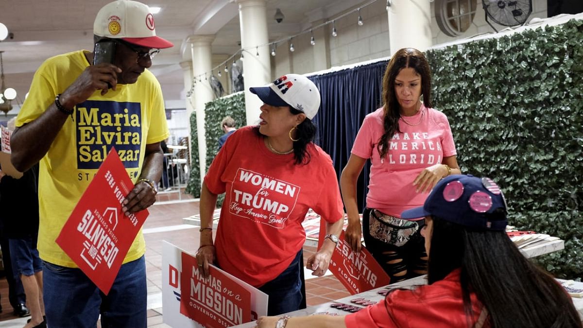 People pick up pins as they arrive for a rally with Florida Governor Ron DeSantis ahead of the midterm elections, in Hialeah, Florida. Credit: Reuters photo