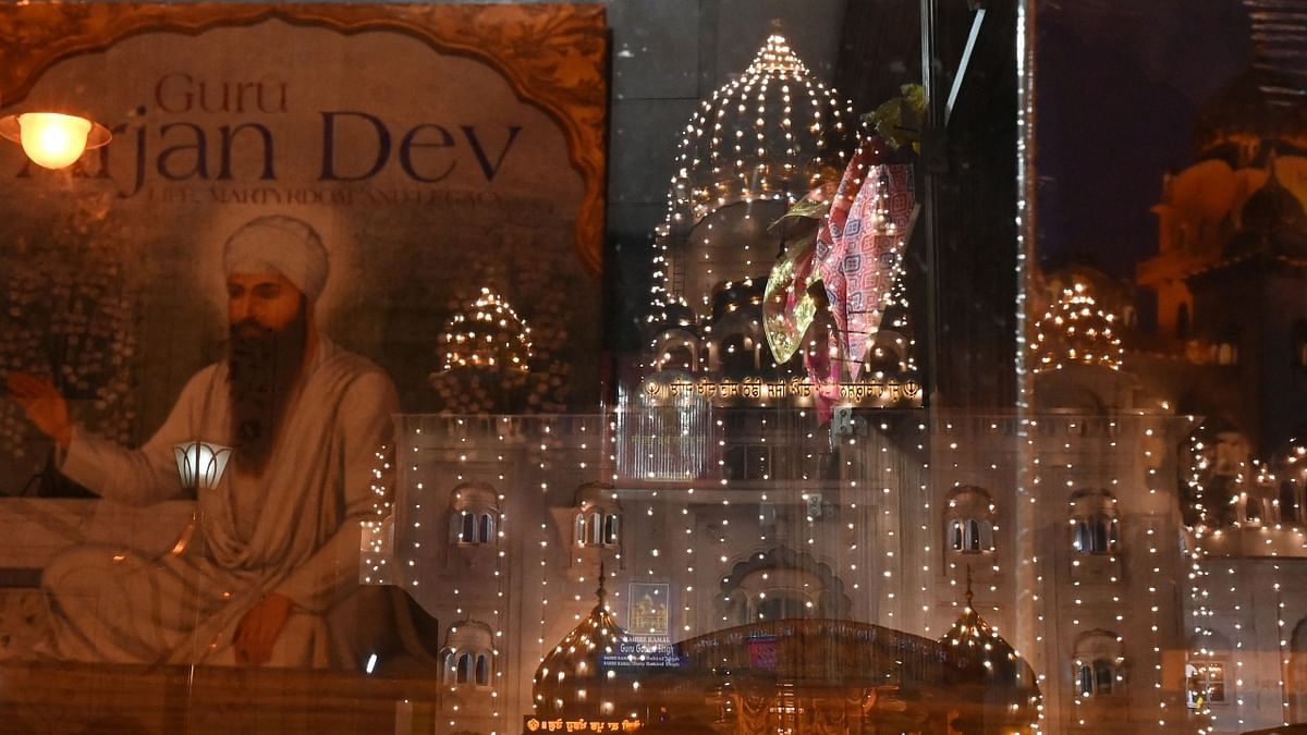 The illuminated Gurudwara Shri Bangla Sahib is seen reflected from a shop mirror on the occasion of the birth anniversary of Guru Nanak Dev in New Delhi. Credit: AFP Photo