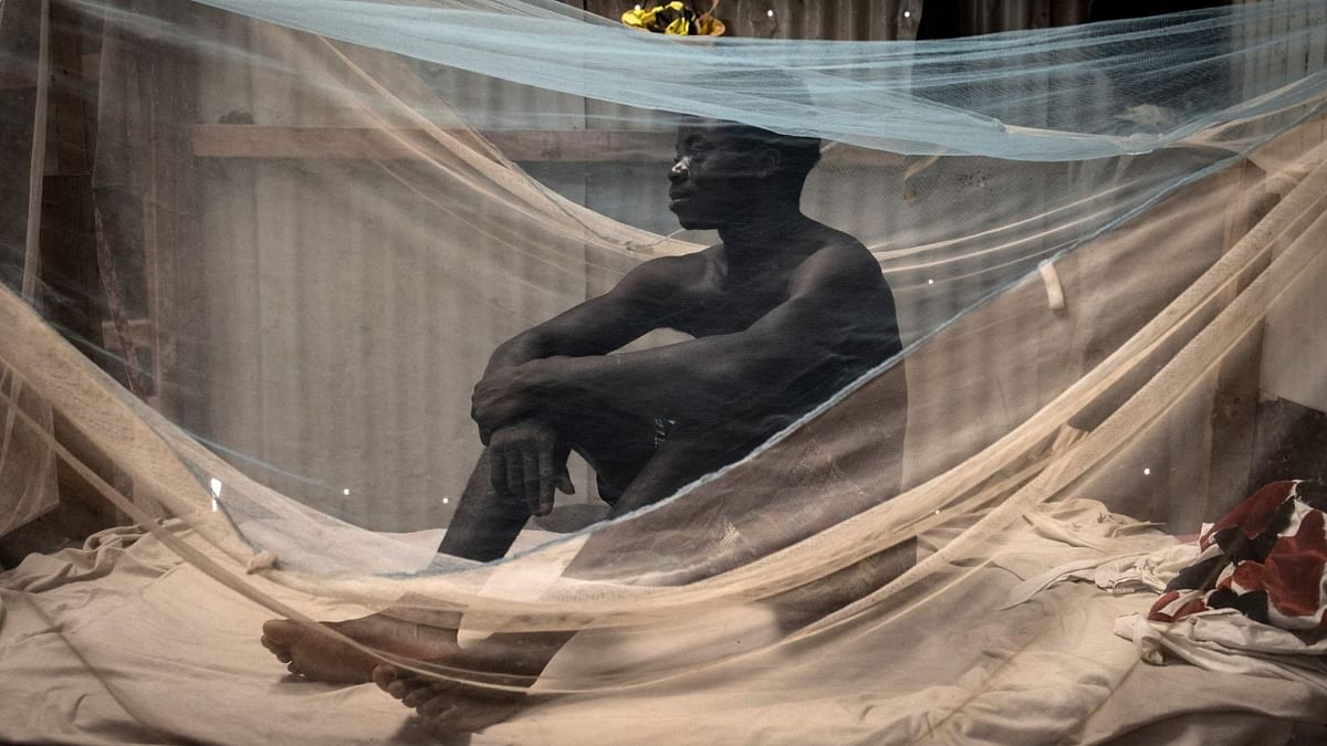 A construction worker from Sierra Leone sits on his bed at a camp in Diamniadio on November 8, 2022. Credit: AFP Photo