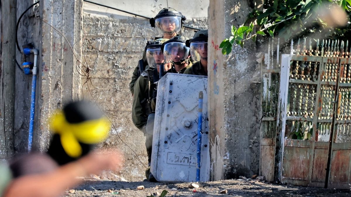 Palestinian demonstrators and Israeli forces clash following a protest against the expropriation of Palestinian land by Israel, in the village of Kfar Qaddum in the occupied West Bank, near the Jewish settlement of Kedumim, on November 11, 2022. Credit: AFP Photo