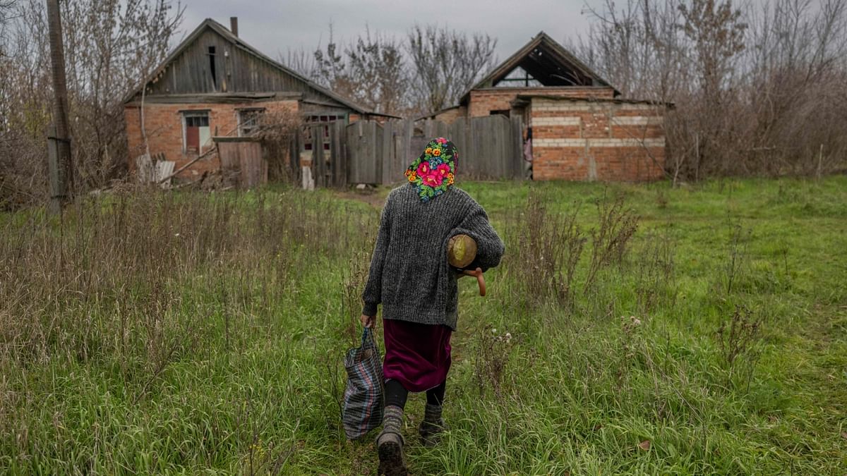 Ukrainian woman comes back home with some wood in Siversk, a town in eastern Ukraine hit by Russian forces couple of days ago, on November 11, 2022, amid the Russian invasion of Ukraine. Credit: AFP Photo