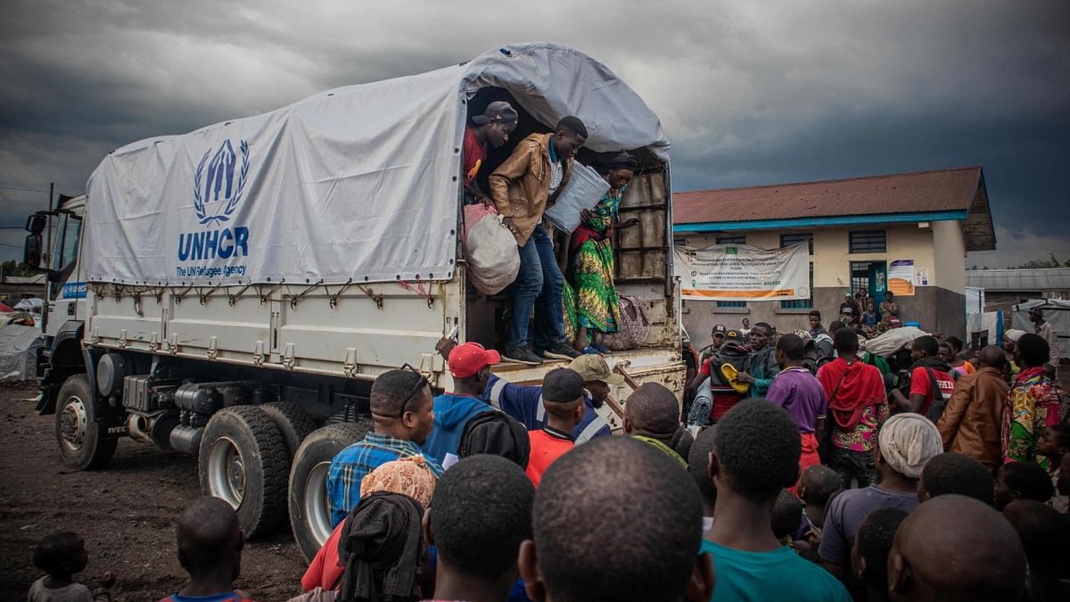 Internally displaced people get off from a United Nations High Commissioner for Refugees (UNHCR) truck in Kanyaruchinya on November 11, 2022 after fleeing conflict between the Armed Forces of the Democratic Republic of the Congo (FARDC) and M23 (March 23 Movement) in the territory of Rutsuru in the DRC. Credit: AFP Photo