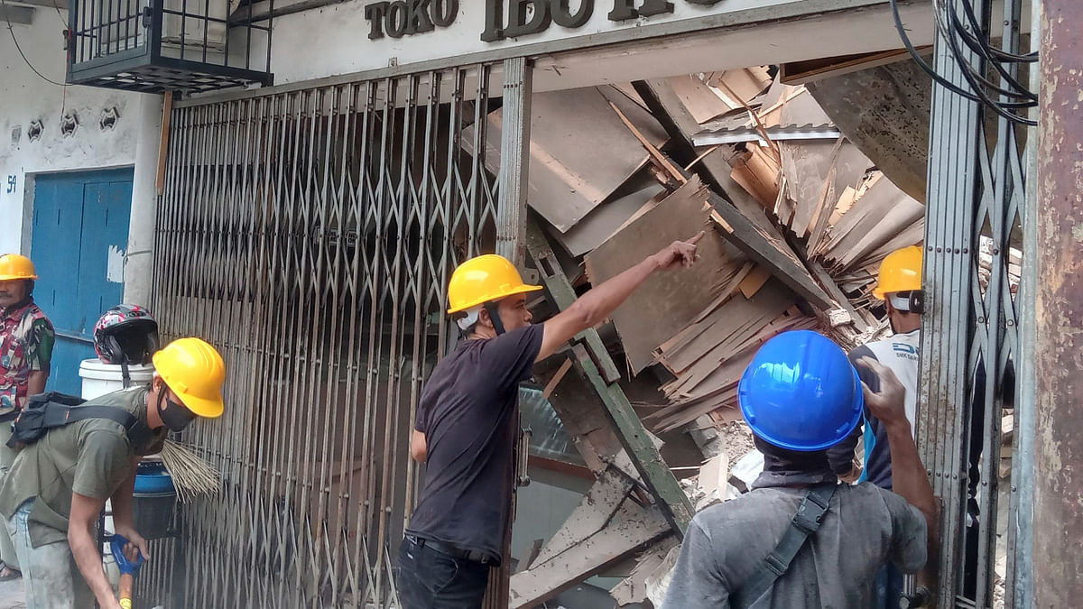 Workers inspect a store that got damaged during the earthquake that shook Indonesia's main island of Java. Credit: AP/PTIPhoto
