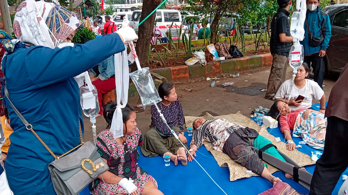 People injured during an earthquake receive medical treatment in a hospital parking lot in Cianjur. Credit: AP/PTI Photo