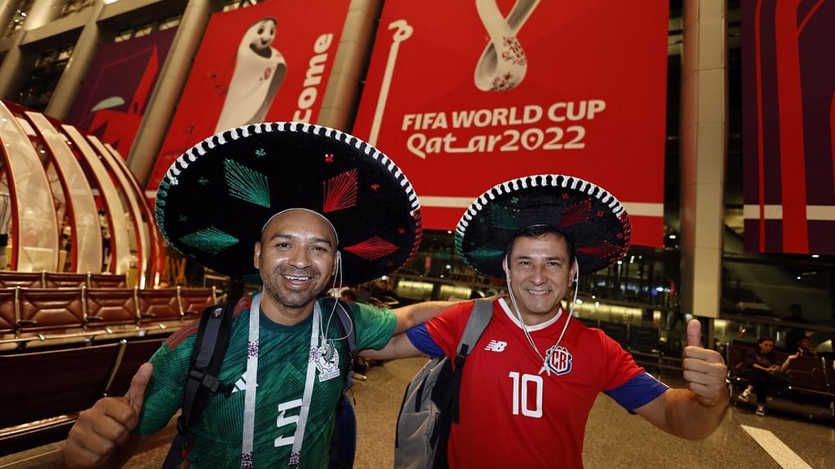 A Mexico fan and a Costa Rica fan pose after they arrive in Qatar. Credit: Reuters Photo