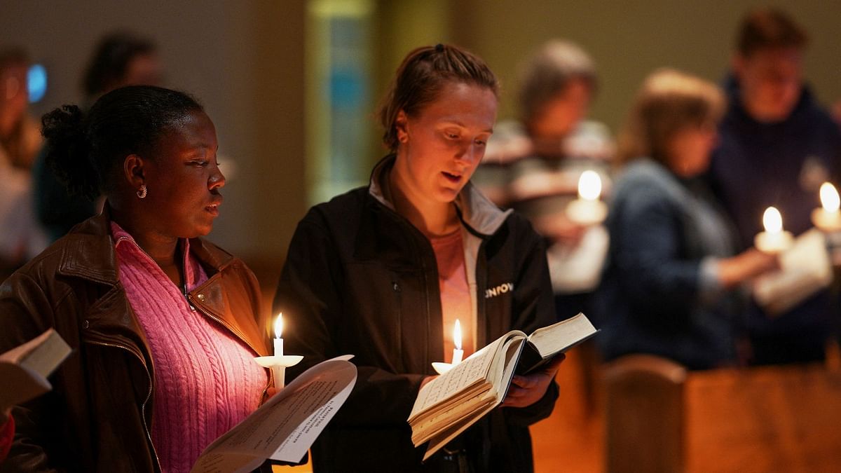 Alexandra Bernier and Maya McKone-Sweet sing a hymn during a vigil at St. Thomas Episcopal Church after a mass shooting at a Walmart in Chesapeake, Virginia, U.S. Credit: Reuters Photo