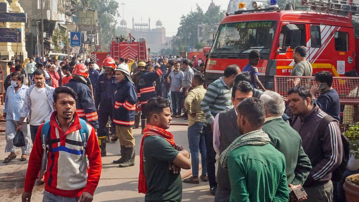 Fire Brigade personnel and shopkeepers are seen on the site in Delhi on November 25, 2022. Credit: PTI Photo