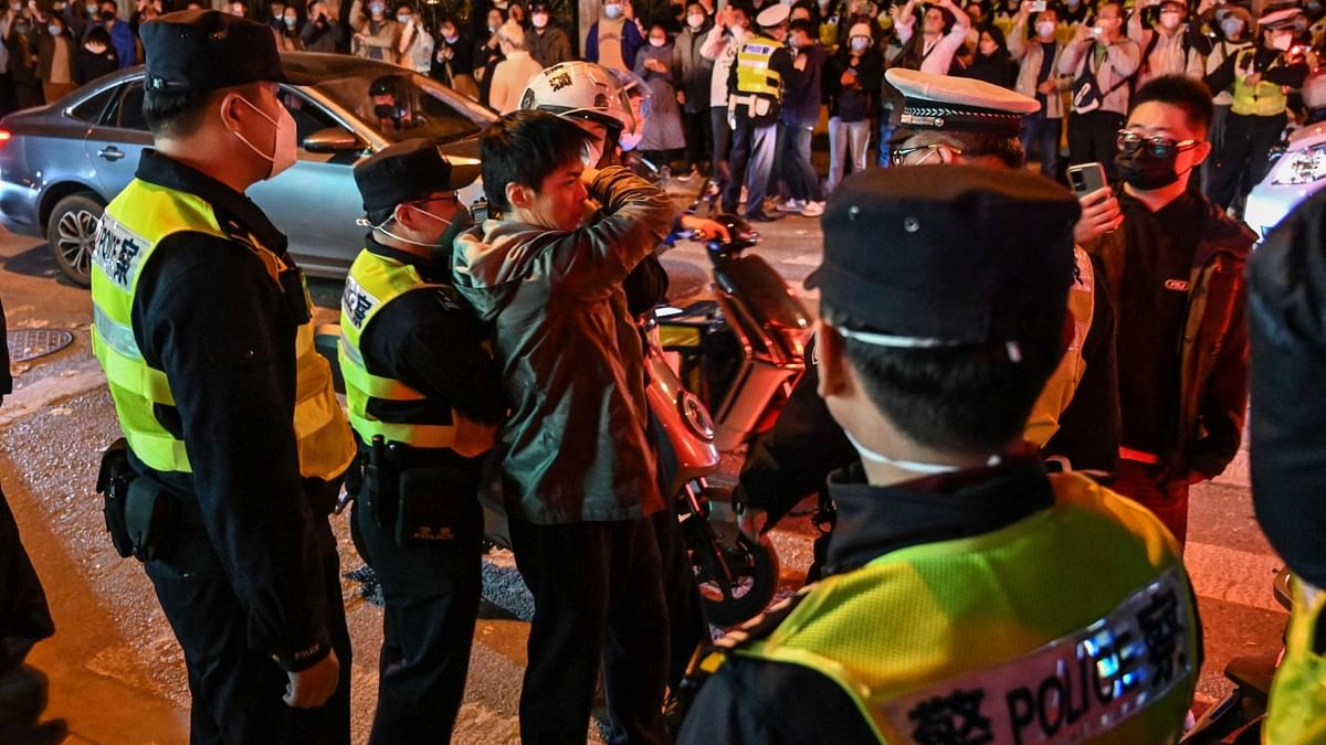 In Shanghai, cops clashed with groups of protesters as officers tried to move people away from the site of an earlier demonstration on Wulumuqi street. Credit: Reuters Photo