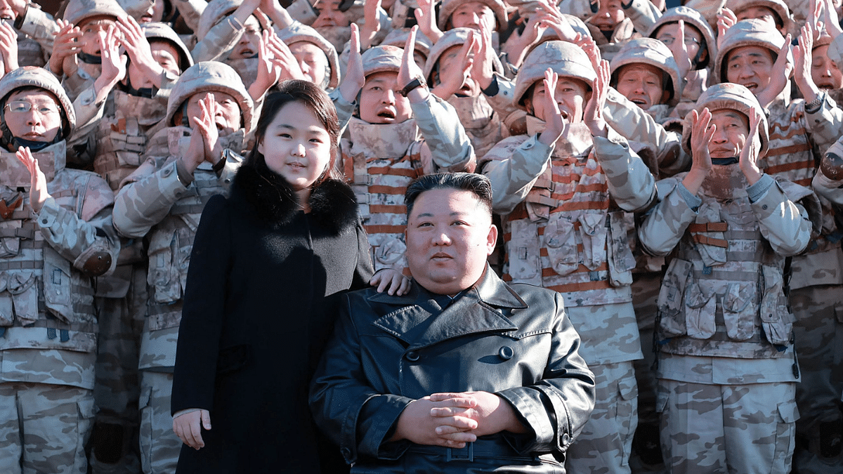 This undated picture released from North Korea's official Korean Central News Agency (KCNA) on November 27, 2022 shows North Korea's leader Kim Jong Un (front R) and his daughter (front L) posing with soldiers who contributed to the test-firing of the new intercontinental ballistic missile (ICBM), at an unknown location in North Korea. Credit: AFP Photo