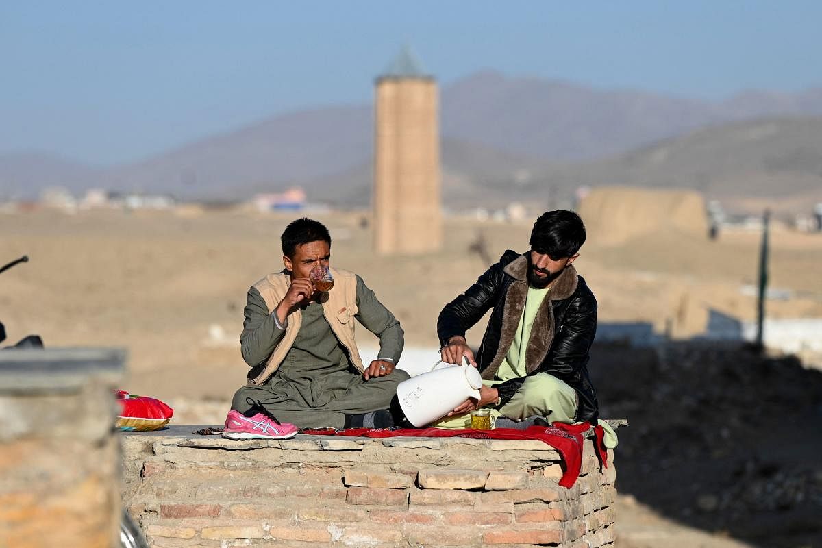 Afghan men drink tea near a historic minaret in the north-east of Ghazni province. Credit: AFP Photo