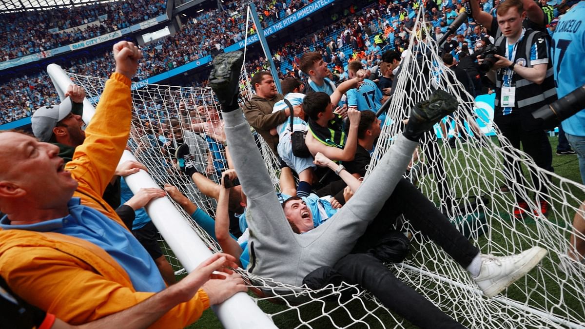 Manchester City fans celebrate on the pitch after winning the Premier League. Credit: Reuters Photo