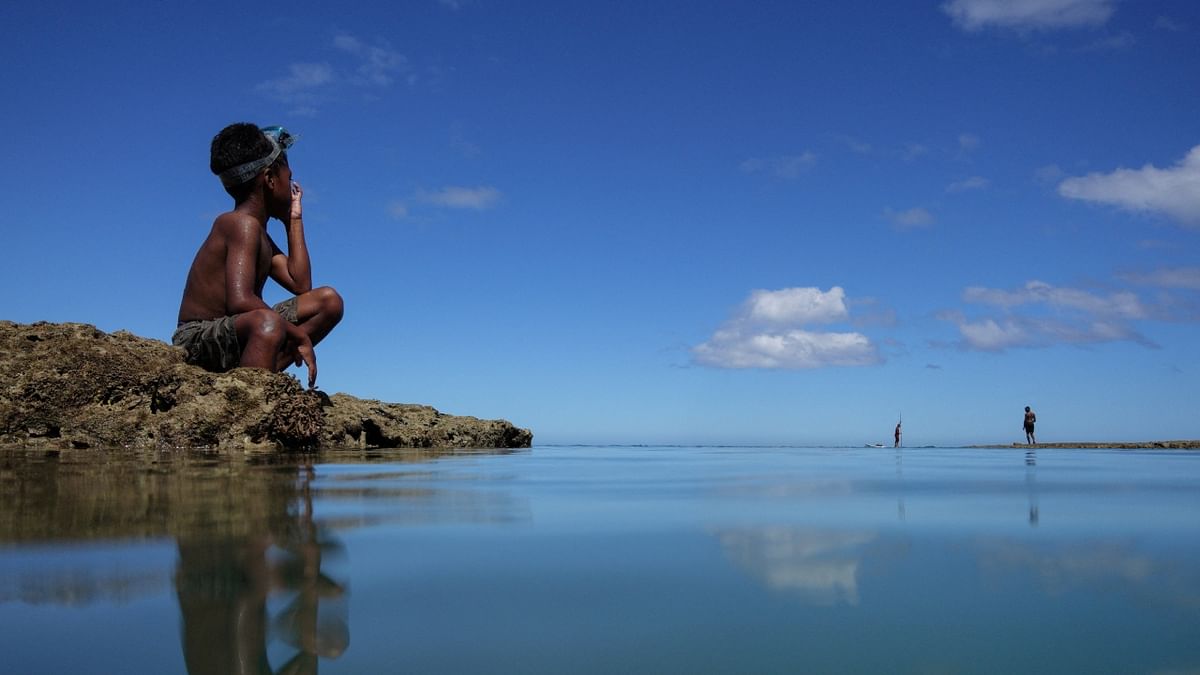 A child takes a break from diving in the sea at Serua Village, Fiji. The community runs out of ways to adapt to the rising Pacific Ocean, the villagers face the painful decision whether to move or not fearing for life. Credit: Reuters Photo