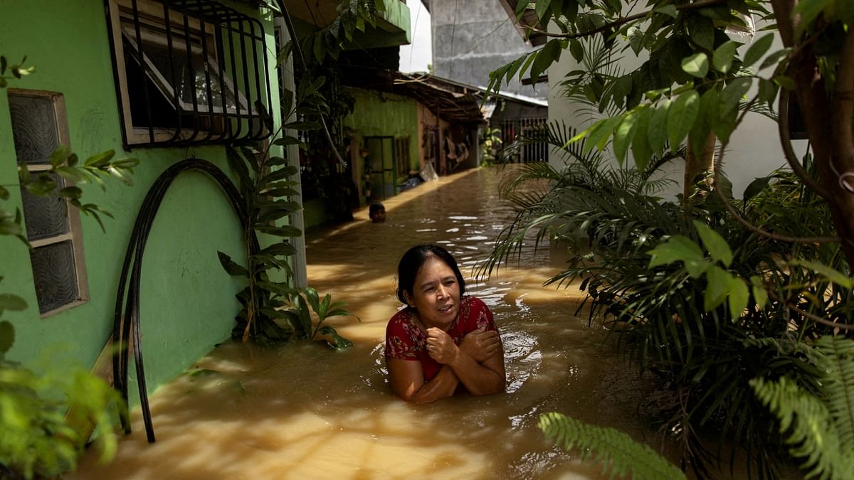 A woman wades through chest-deep flood after Super Typhoon Noru, in San Ildefonso, Bulacan province, Philippines. Credit: Reuters Photo