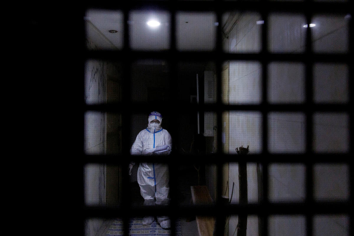 A pandemic prevention worker in a protective suit approaches an apartment in a building that went into lockdown as coronavirus disease outbreaks continue in Beijing. Credit: Reuters Photo