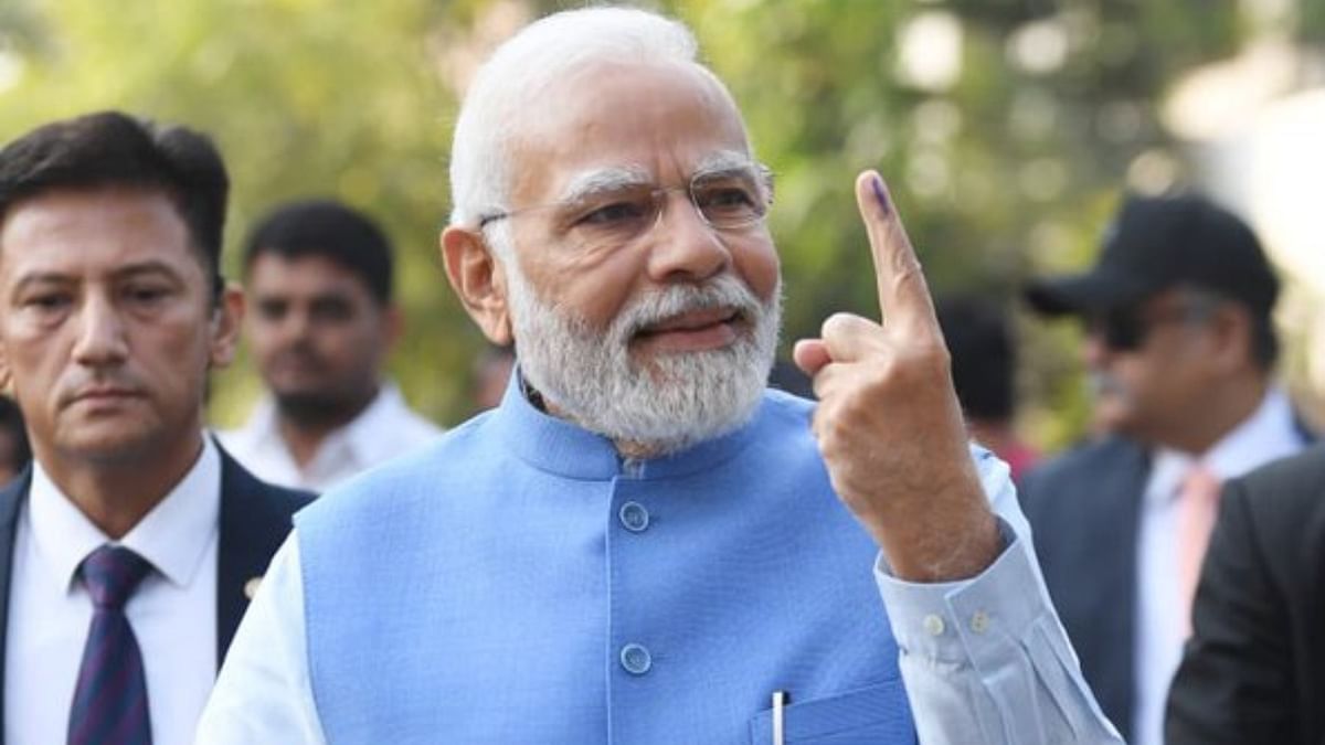 Prime Minister Narendra Modi shows his inked finger after casting vote during the second and final phase of Gujarat Assembly elections at Ranip in Ahmedabad. Credit: Twitter/@narendramodi