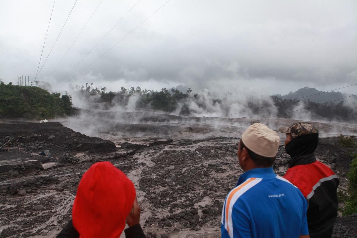 Villagers watch hot smoke from the ground following Mount Semeru's volcanic eruption in Lumajang, East Java. Credit: AFP Photo