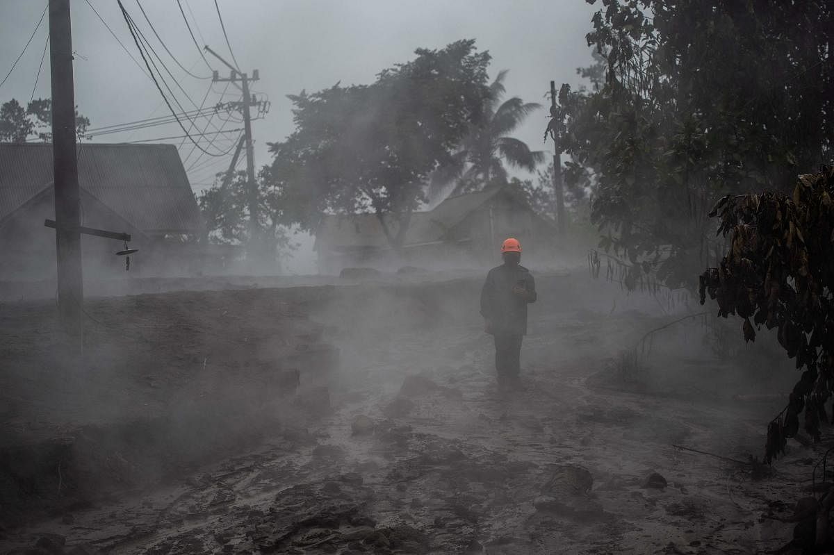 A member of a search and rescue team checks the situation at the Kajar Kuning village in Lumajang. Credit: AFP Photo