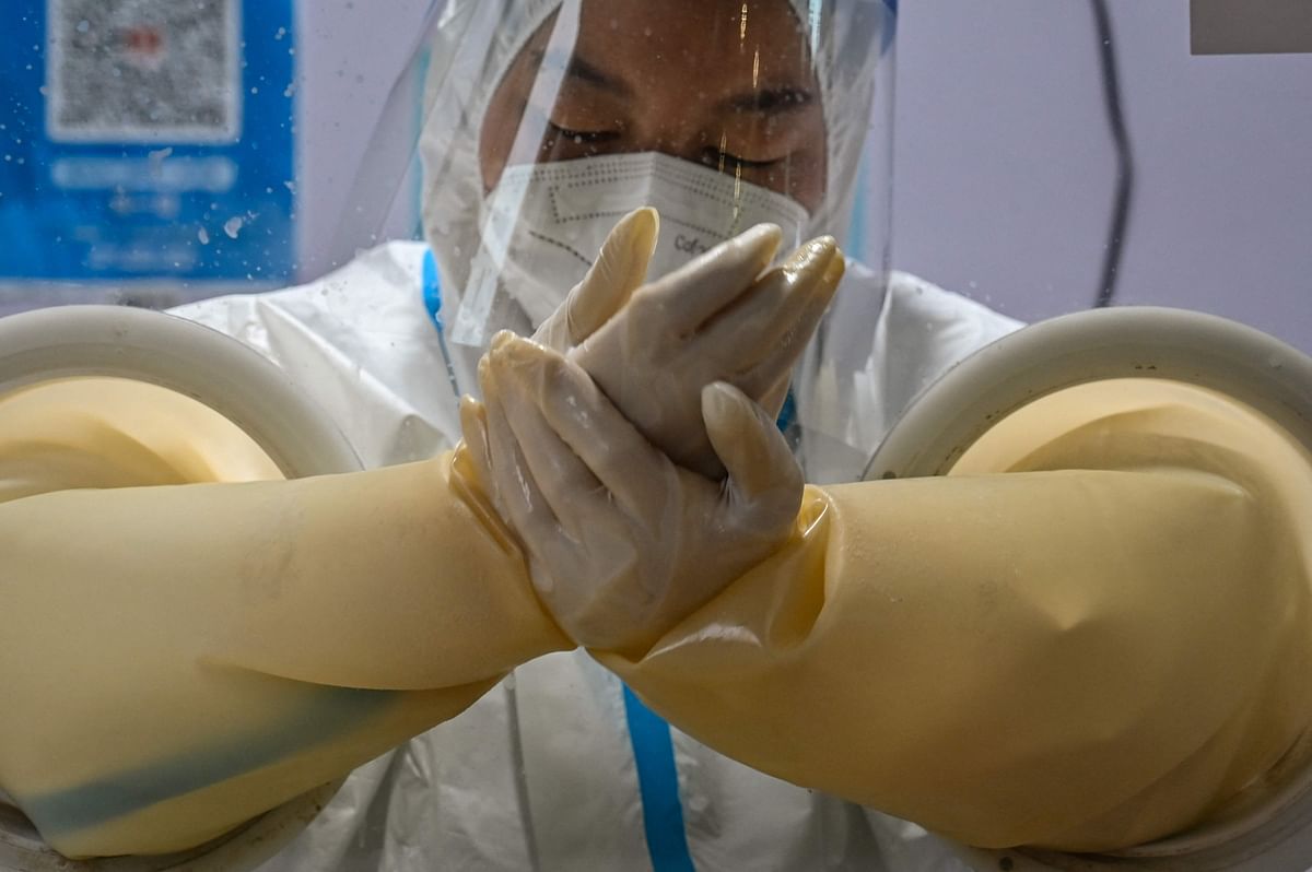 A health worker prepares to take a swab sample from a person to test for the Covid-19 coronavirus in the Jing'an district in Shanghai on December 7, 2022. Credit: AFP Photo