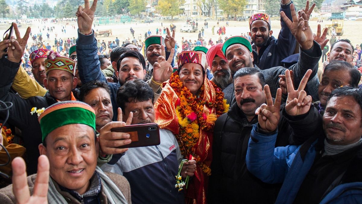 Congress candidate Sunder Singh Thakur flashes the victory sign as he celebrates his win in the Himachal Pradesh Assembly elections, in Kullu. Credit: PTI Photo