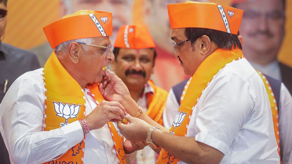 Gujarat Chief Minister and BJP candidate Bhupendra Patel and party's state President CR Patil offer each other sweets, celebrating the party's victory in the Gujarat Assembly elections, at party HQ in Gandhinagar. Credit: PTI Photo