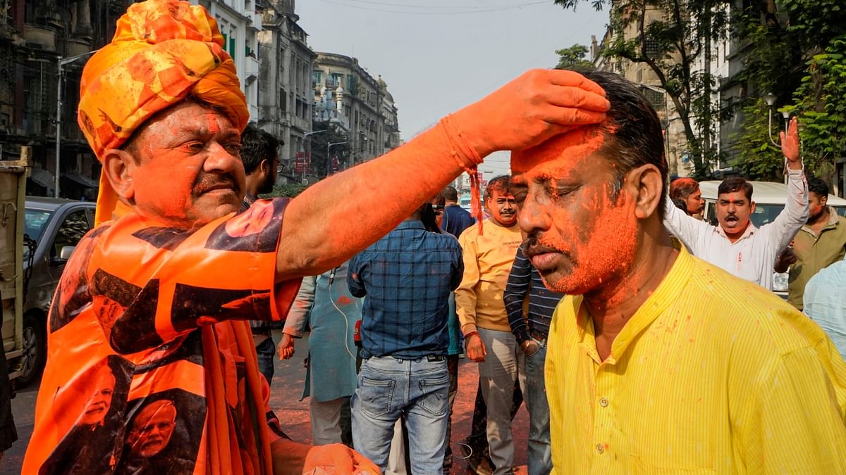 A BJP worker smears colour, celebrating the party's victory in the Gujarat Assembly elections, in Kolkata. Credit: PTI Photo
