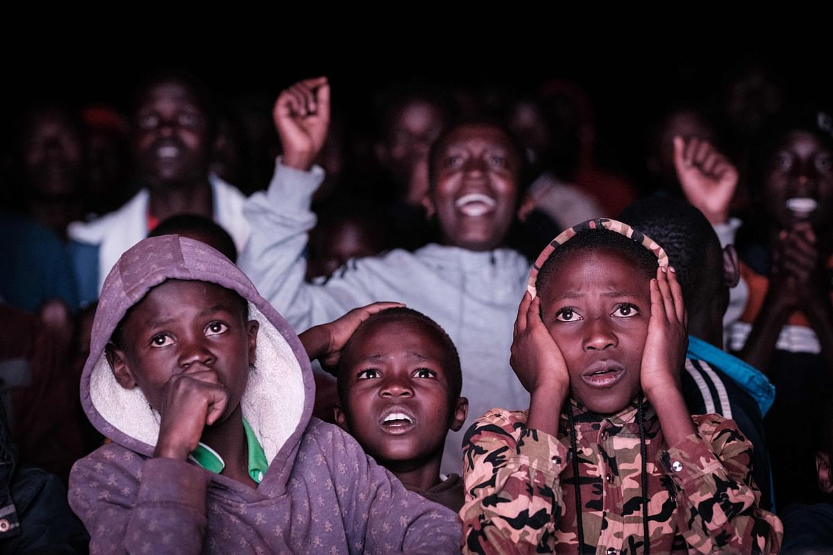 Kenyan football fans watch on the screen installed in a field during the Qatar 2022 World Cup quarter-final football match between Morocco and Portugal at Kibera slum in Nairobi. Credit: AFP Photo
