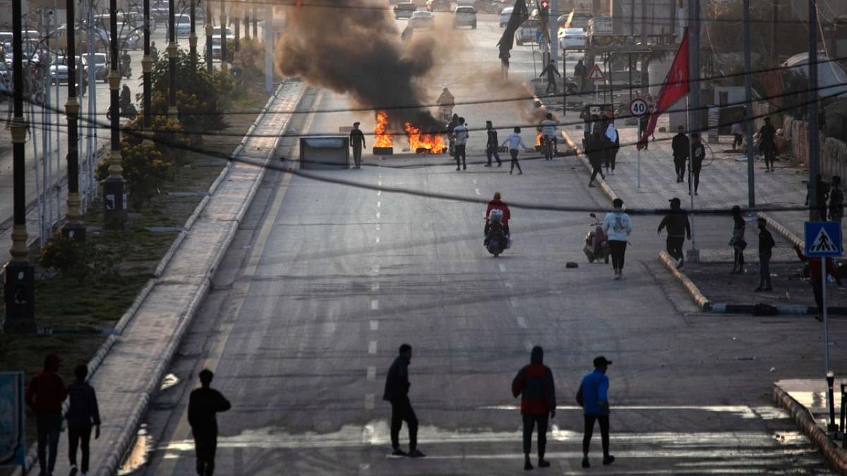 Iraqi demonstrators block a road with burning tyres as they protest the death of fellow protestors in clashes with security forces, in the southern city of Nasiriyah. Credit: AFP Photo