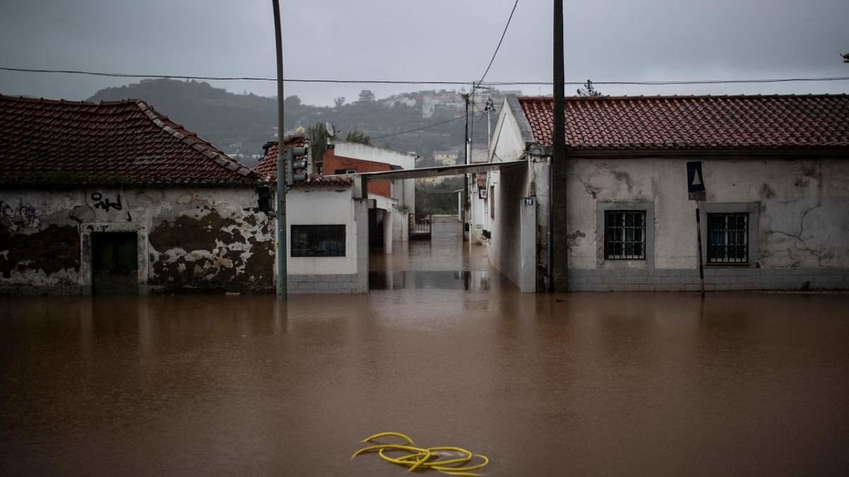 A hose is pictured in the middle of a flooded street, in Frielas, on the outskirts of Lisbon. Credit: AFP Photo