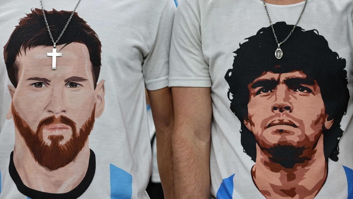 Argentina supporters wear t-shirts displaying portraits of Argentina's forward #10 Lionel Messi (L) and late football legend Diego Maradona before the start of the Qatar 2022 World Cup football semi-final match between Argentina and Croatia. Credit: AFP Photo