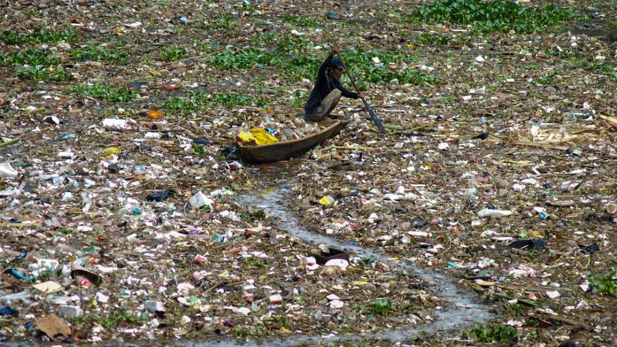 A man collects plastic from the polluted Citarum river in West Bandung. Credit: AFP Photo
