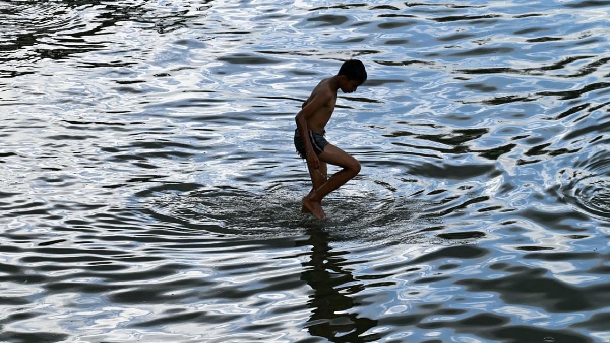 A boy stands in shallow water by a beach in Banda Aceh. Credit: AFP Photo